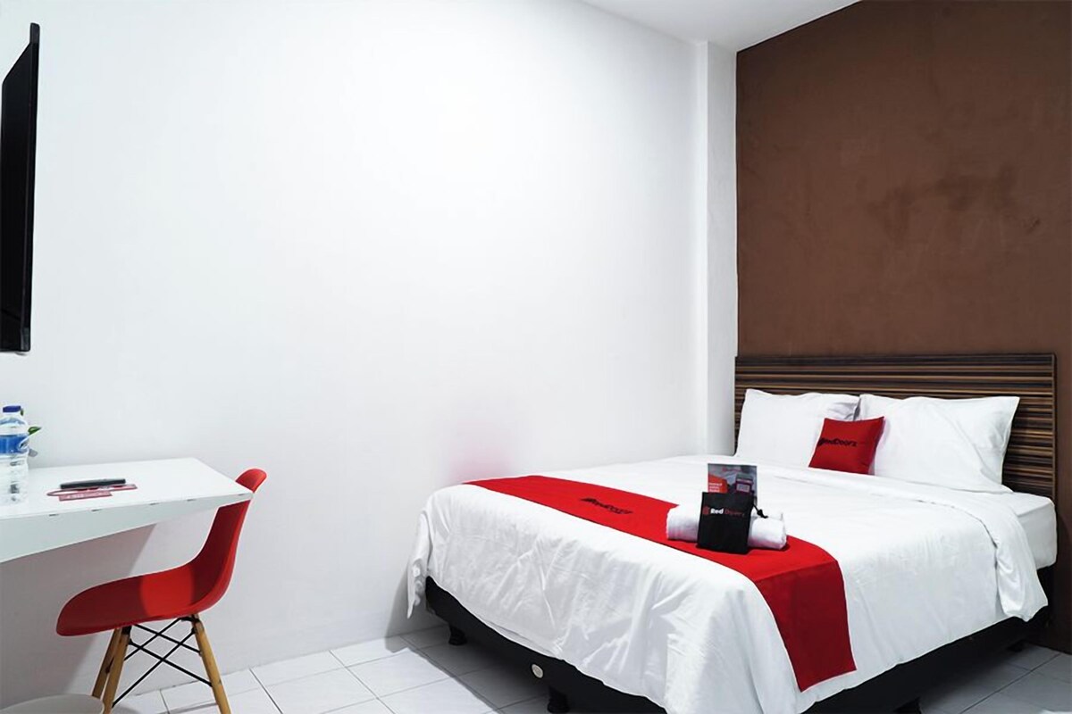 Una habitación de hotel con una cama, un escritorio y una silla.