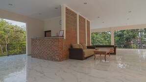 A spacious lobby with a marble floor, a brick fireplace, a sofa, and a coffee table.