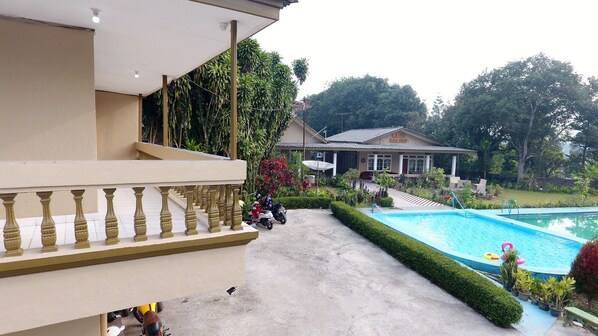 A hotel with a swimming pool, a covered balcony, and a garden. - Residences by RedDoorz near Taman Safari (Cisarua)