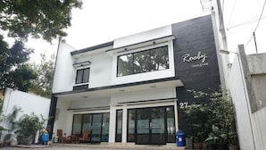 Un edificio moderno con fachada blanco y negro, ventanas amplias y un letrero que dice 