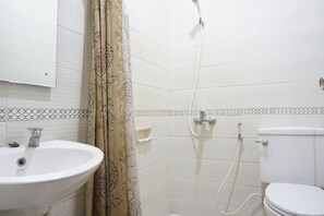 Bathroom features a sink, toilet, and shower area with a floral-patterned shower curtain.