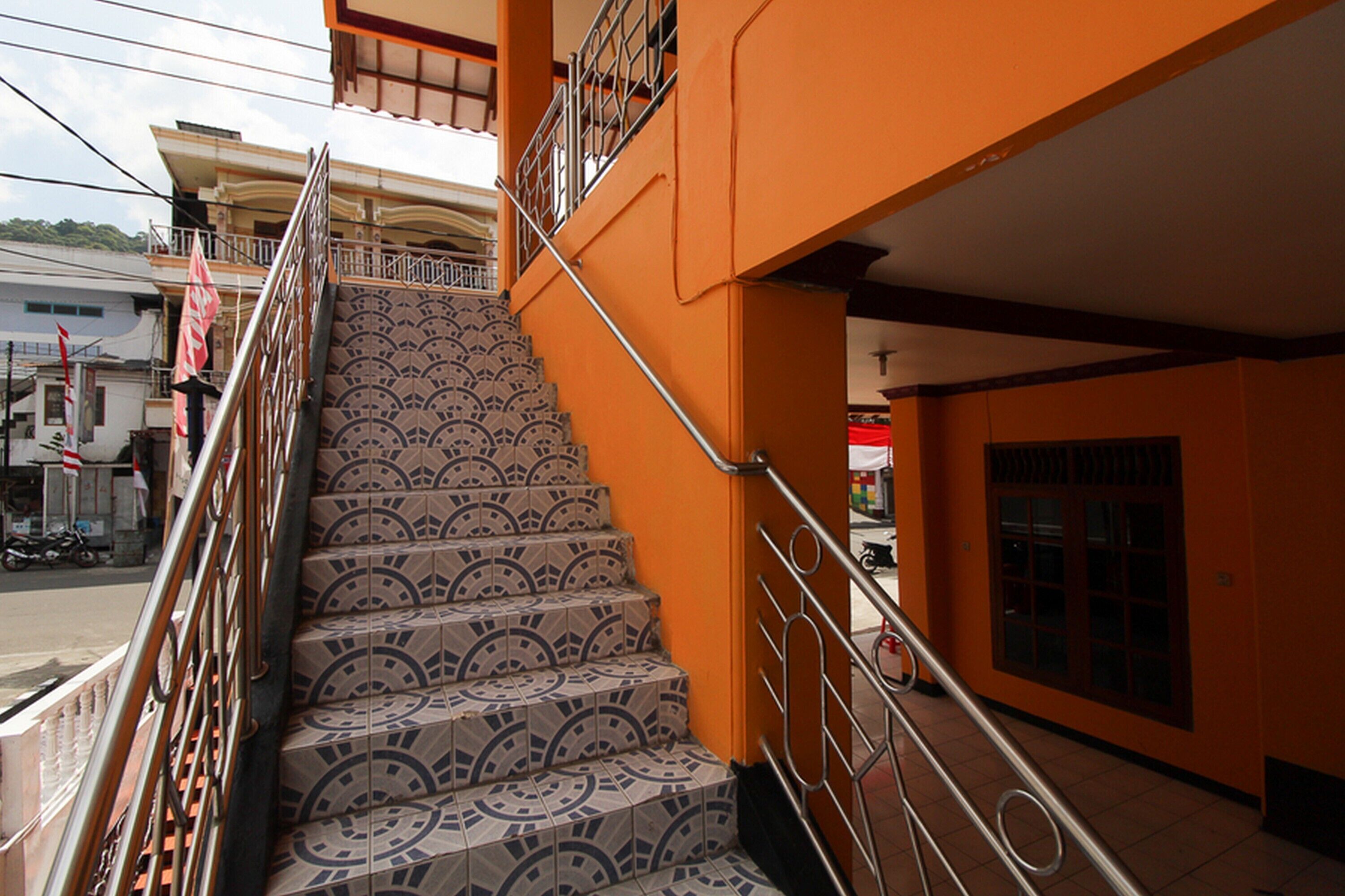 Una escalera con baldosas estampadas que lleva a un balcón.