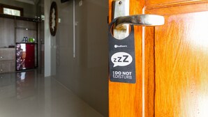 A wooden door with a 'Do Not Disturb' sign and a RedDoorz logo. - RedDoorz near Parangtritis Beach (Parangtritis)