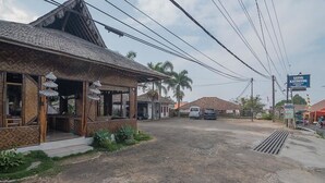 A building with a traditional design, featuring a sloped roof and patterned exterior. - RedDoorz near Happy Farm Ciwidey (Rancabali)