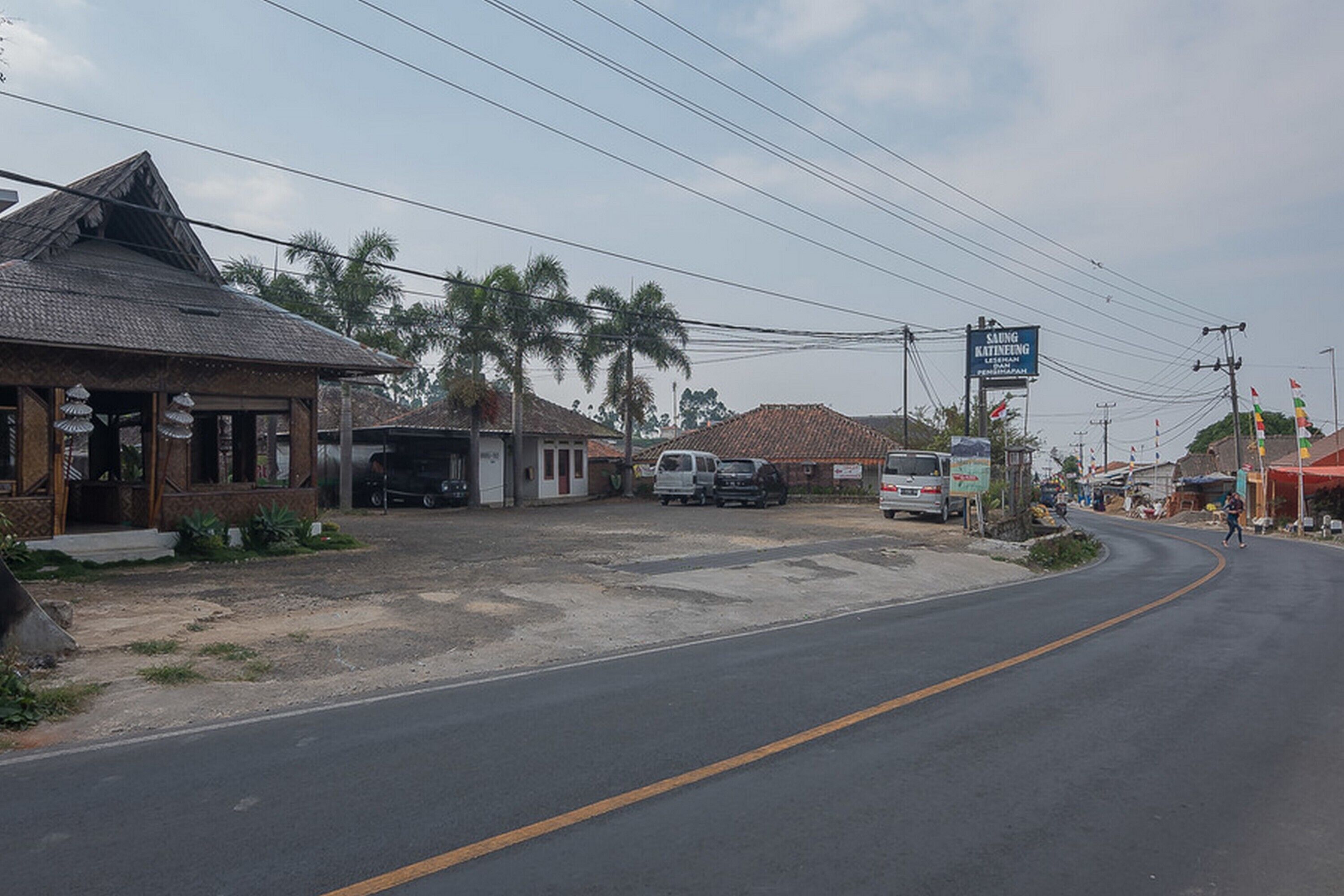 A street with buildings, a road, and a signboard.