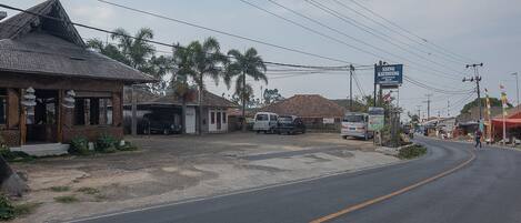 A street with buildings, a road, and a signboard.