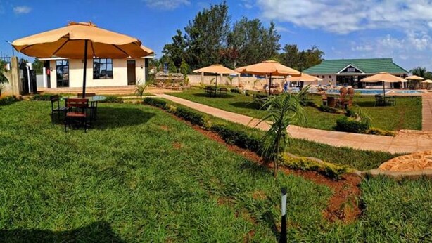 Un complejo turístico con zonas de estar al aire libre, piscina y un jardín bien cuidado.