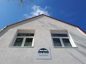 Ein Gebäude mit zwei Fenstern und einem Schild, auf dem „EIN BETT im Norden APPARTMENTS“ steht.