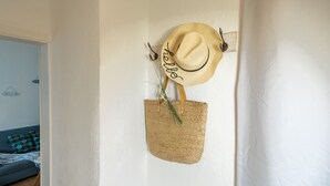 Un chapeau de paille et un sac tressé sont accrochés au mur.