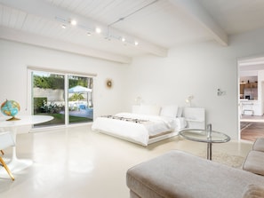 Un dormitorio moderno con una cama grande, una mesita de cristal y vistas al exterior.