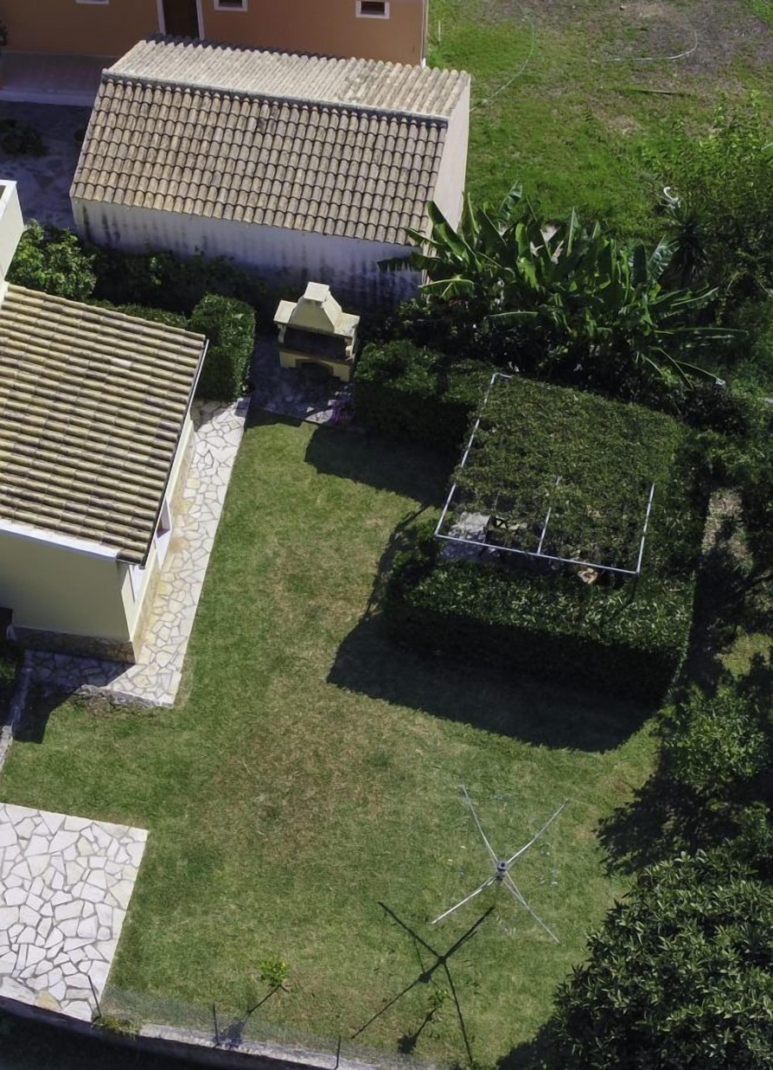 A residential property with a tiled roof, a well-maintained lawn, and a small garden area.
