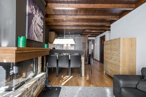 Een moderne keuken met een centraal eiland, houten balken in het plafond en een stenen openhaard.