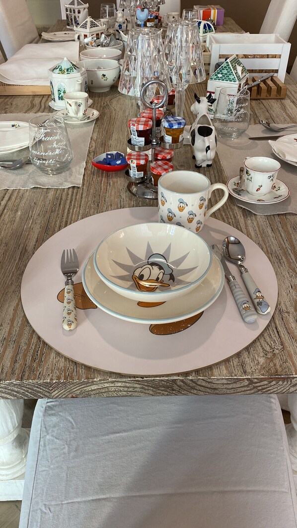 A dining table set with a variety of tableware including plates, bowls, cups, and cutlery. - Maison de Famille (Palermo)