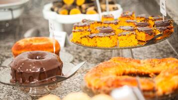 Diverses postres exposades, com un pastís bundt cobert de xocolata, una porció de pastís de calabacín i altres productes de forneria.