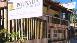 A building with a sign reading "Pousada Recanto do Mucugê" and contact information. - Pousada Recanto do Mucugê (Porto Seguro)