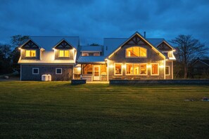 A large, two-story house with a well-maintained lawn in front. - Beach Front Estate Custom Timber Frame Home on Cleveland Beach 72 (Hubbards)