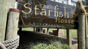 Une enseigne en bois portant l’inscription « The Starfish House » et « Chinofestacue », indiquant qu’il s’agit d’un établissement à thème.