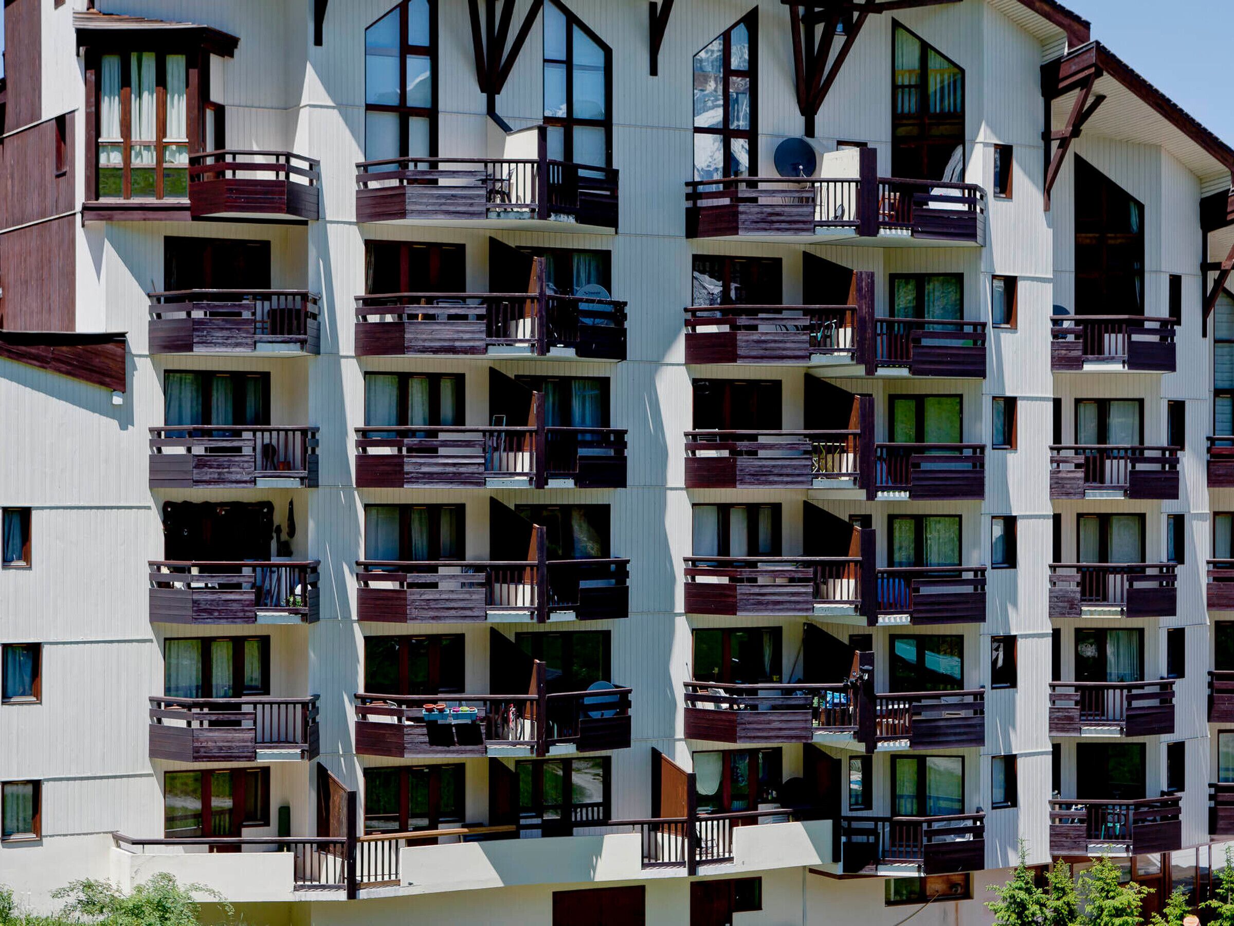 Et hotel med flere etager, altaner, store vinduer og moderne arkitektur.