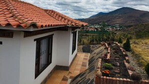A white building with a terracotta roof and a tiled patio. - Hotel Duna Campestre (Sáchica)