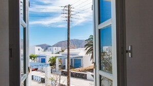 A view from an open window with a clear sky and distant mountains.