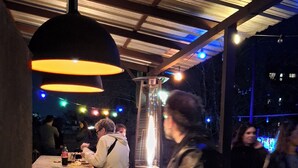 A bar area with a counter, hanging lights, and a metal structure. - 06 Soho Suites Bed & Breakfast (Buenos Aires)