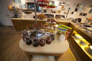 A buffet with various food items and beverages, including a box of Nestlé Quik. - AlmaBagi Hotel&Villas (Quba)