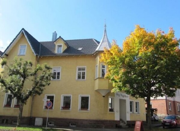 A yellow building with a steeply pitched roof, a small tower-like structure, and a sign reading "St. Peter's Church".