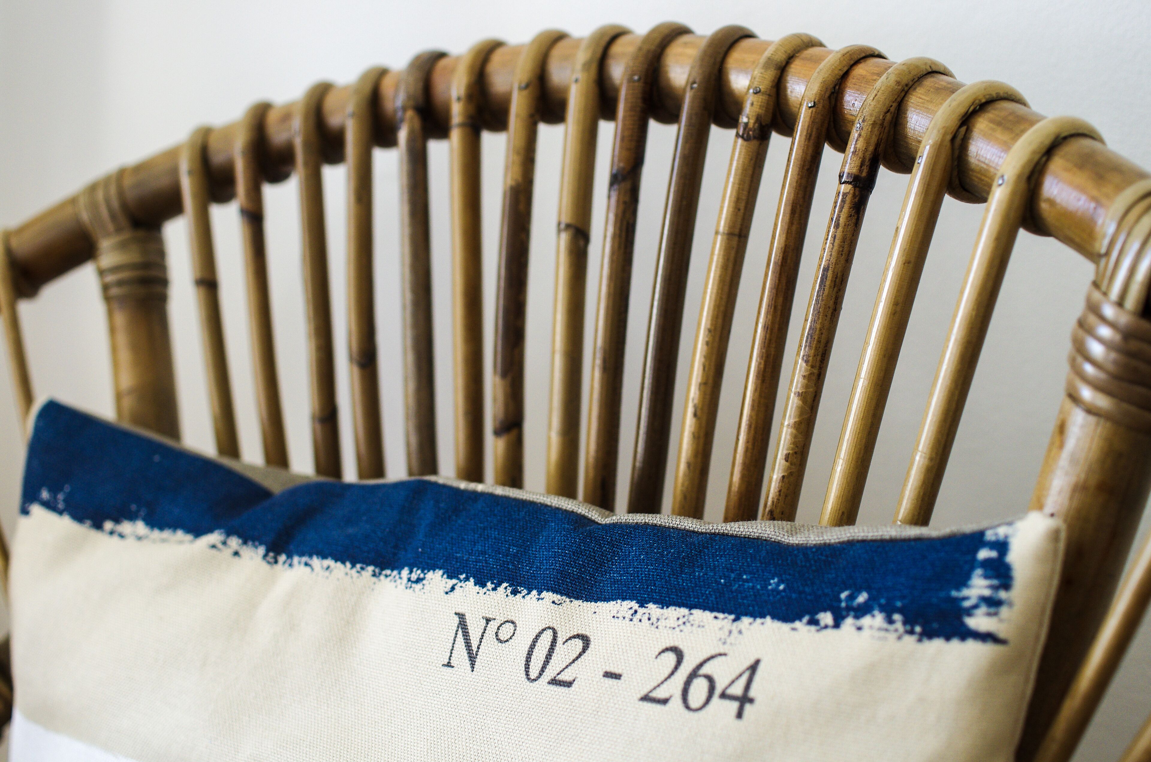 A wooden chair with a fabric backrest labeled "Nº 02 - 264".