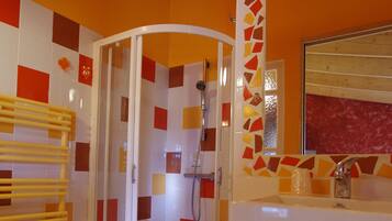 Ein Badezimmer mit Dusche, Waschbecken und Spiegel.