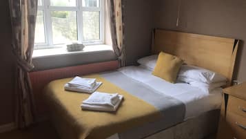Relax in a cozy retreat with a neatly made bed and plush throw blanket.