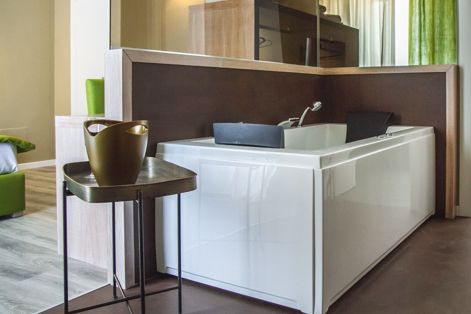 Une cuisine compacte avec un lave-linge blanc, un évier et une petite table sur laquelle est posé un vase.