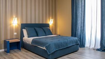 A bedroom with a bed, two bedside tables, and a nightstand.