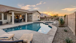 A backyard with a swimming pool, lounge chairs, and a patio area. - Mystic Mirage is truly a desert oasis with pool and mountain views. (Tucson)