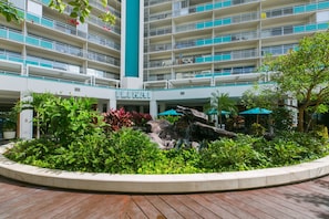 A multi-story hotel with a central atrium, surrounded by lush greenery and a wooden deck. - Ilikai Tower 1934 Condo with Fully Equipped Kitchen - Great for longer stays! by RedAwning (Honolulu)