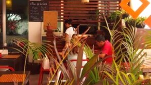 A restaurant with a wooden ceiling, tables, chairs, and potted plants. - Condominio La Dolce Vita (Playa del Carmen)