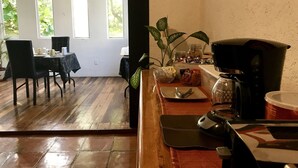 Una cocina con cafetera, un tazón de aperitivos y una planta.