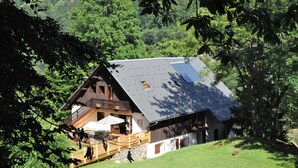 A chalet with a balcony, a wooden deck, and a solar panel on the roof. - Molliessoulaz barn with wolves (Queige)