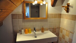 A bathroom with a white sink, wooden cabinets, and a mirror above it. - Molliessoulaz barn with wolves (Queige)