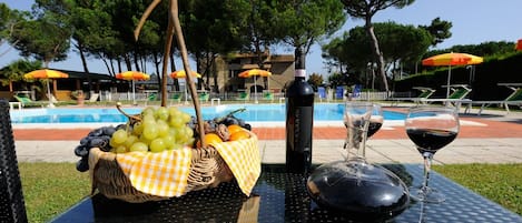 Una piscina al aire libre de temporada, sombrillas, tumbonas