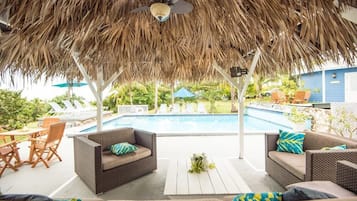 Una piscina al aire libre, sillones reclinables de piscina