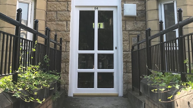 A building with a double door entrance, stone facade, and black iron railings. - McDonald Road Apartment (Edinburgh)