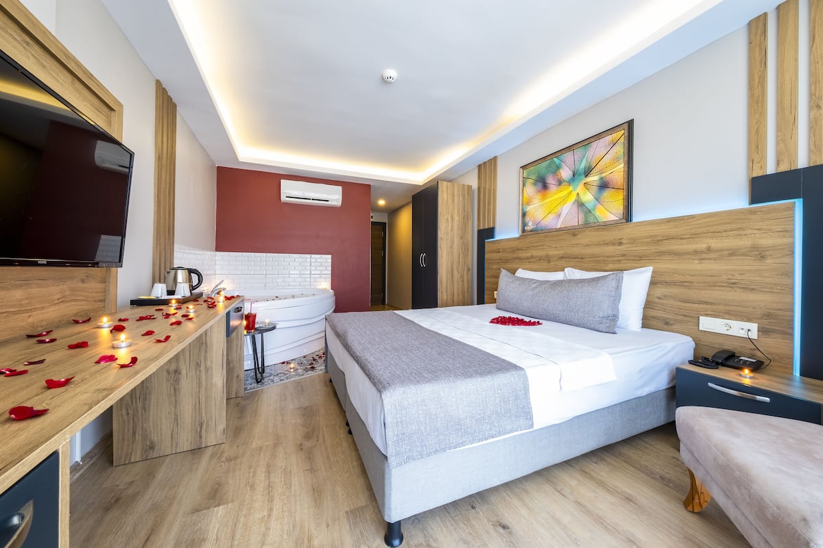 Ein modernes Hotelzimmer mit einem großen Bett, Nachttisch und Fernseher.