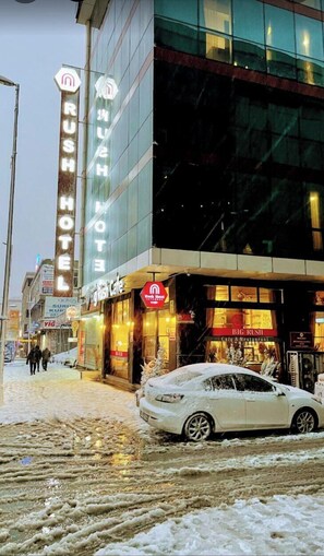 A hotel with a neon sign, a cafe, and a snow-covered street. - Rush Hotel Istanbul (Istanbul)