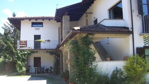 A two-story house with a balcony, a staircase, and potted plants. - Mamota B&B (Vesime)