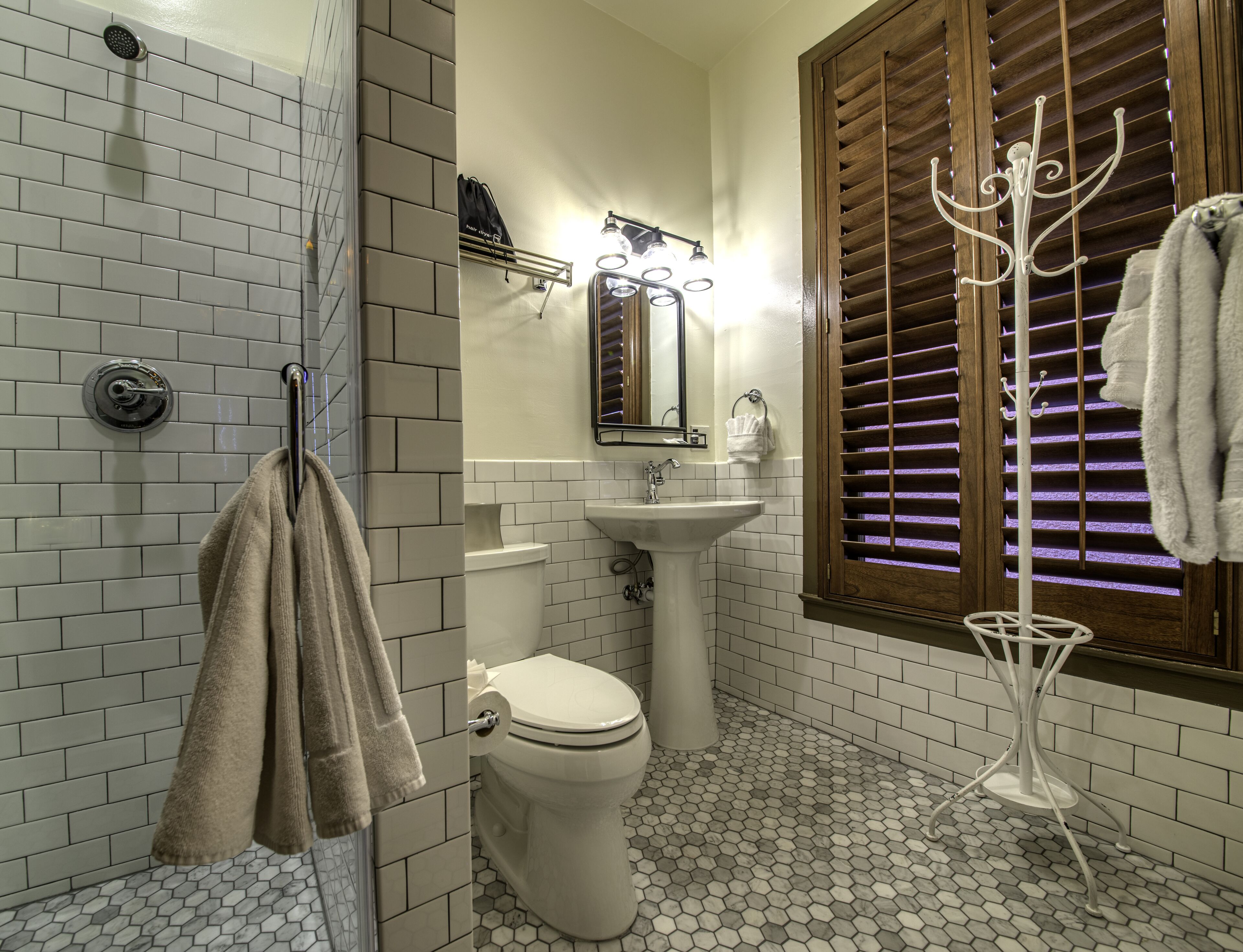 Un baño con ducha, inodoro, lavabo y toallero.