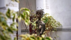 A sculpture of a figure with intertwined elements, set against a backdrop of greenery and architectural details. - Palais Aix Kabaj & Spa (Marrakech)