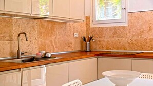 A kitchen with a sink, countertop, and a window. - Villa Le Grotte on the sea Elba Island (Portoferraio)