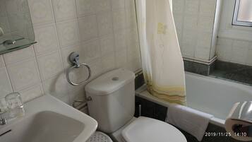 Un baño con inodoro, lavabo y bañera.