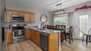 Une cuisine moderne avec des meubles en bois, des appareils en acier inoxydable et un îlot central.
