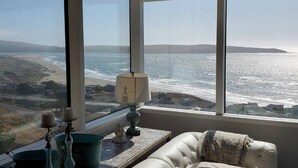 A room with a large window overlooking a beach and ocean. - KH: Life is a Beach (Dillon Beach)